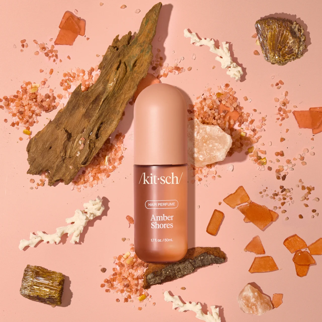 Kitsch Amber Shores hair perfume bottle surrounded by amber, sea salt and coastal elements