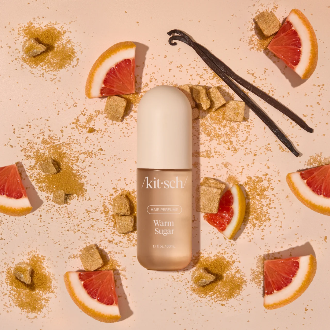 Kitsch Warm Sugar hair perfume bottle surrounded by grapefruit, vanilla and brown sugar