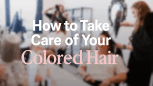 Stylists blow drying and styling hair in a modern salon with text overlay reading “How to Take Care of Your Colored Hair.