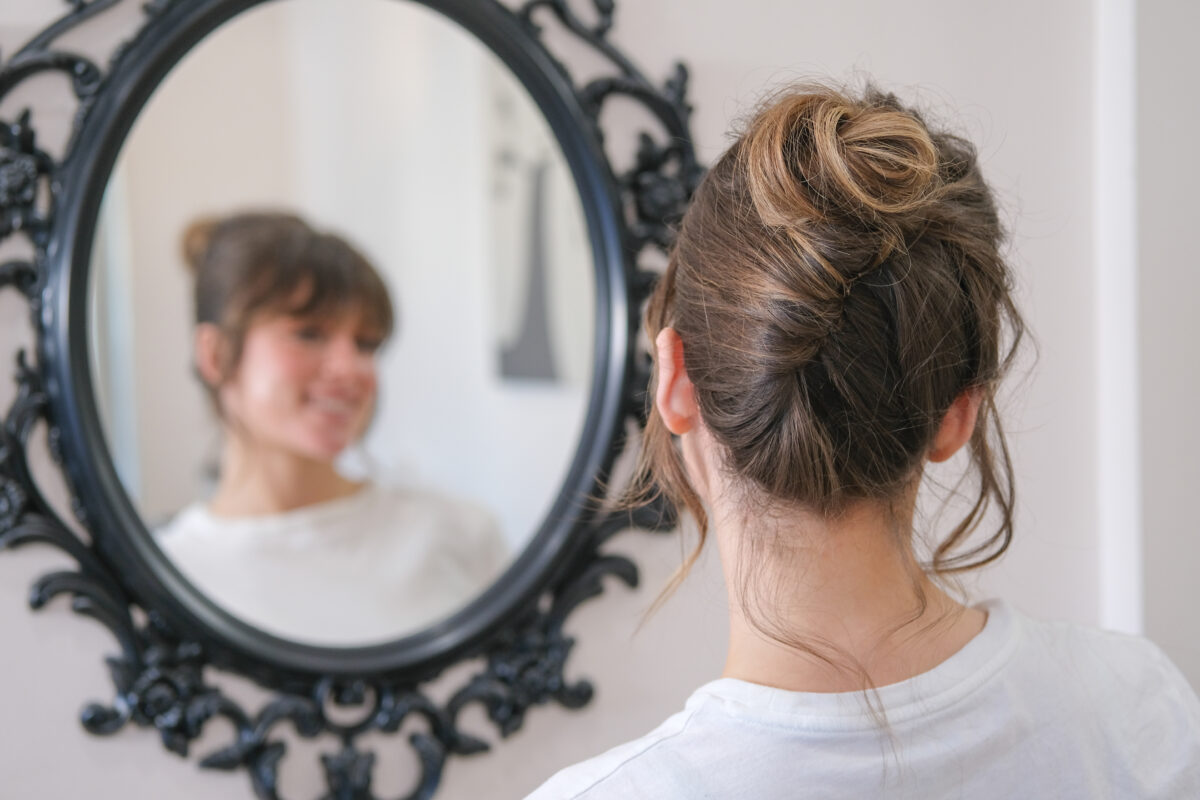 Bride with soft, modern French twist updo featuring loose, textured pieces and a romantic, effortless finish