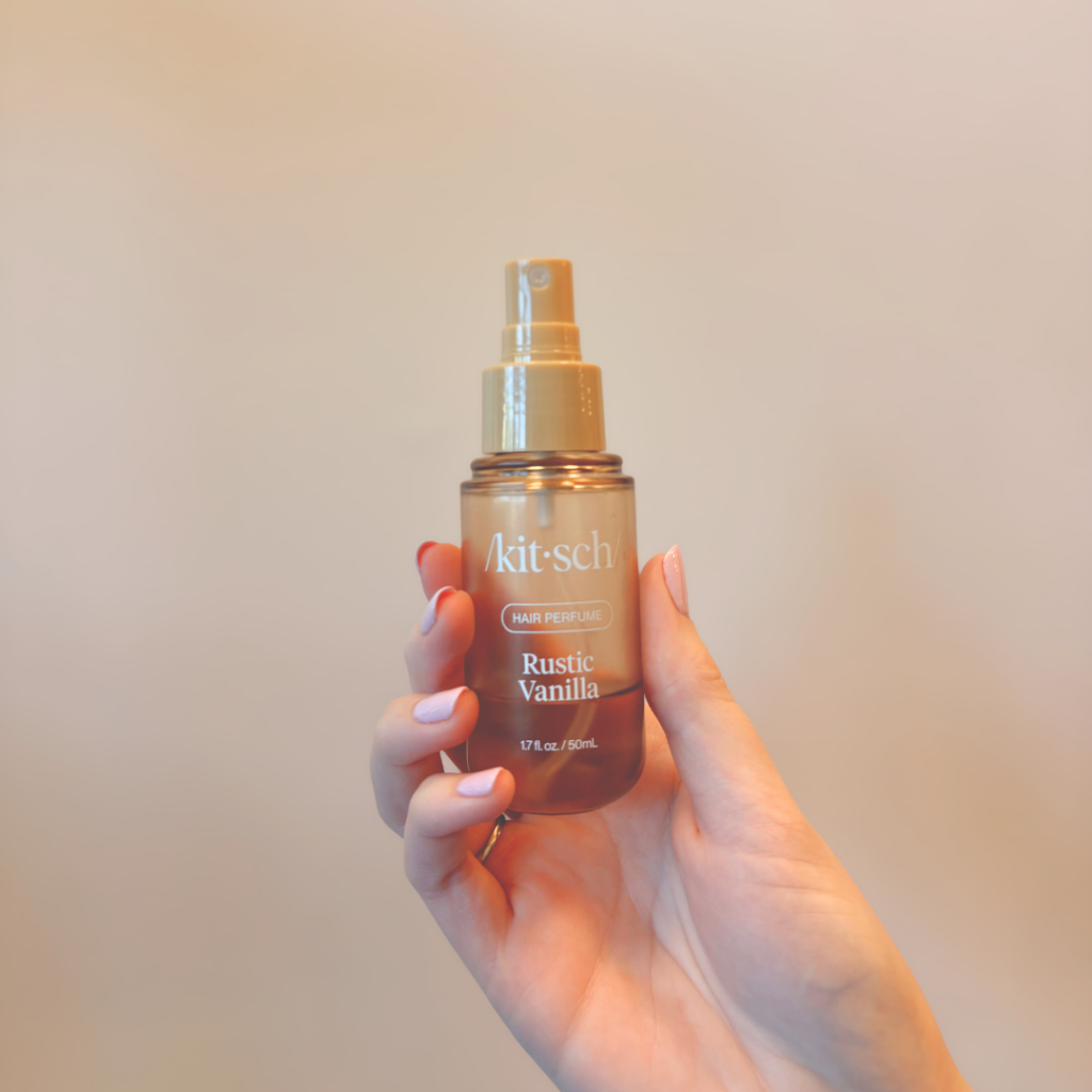 Hand holding a bottle of Kitsch Rustic Vanilla hair perfume
