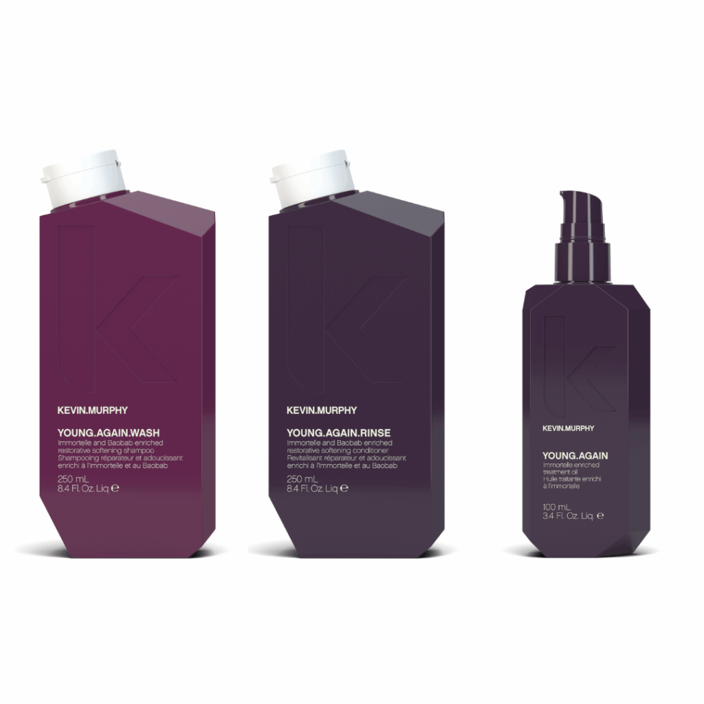 Kevin Murphy Young Again Wash, Rinse, and Treatment bottles in deep plum packaging for restoring softness and shine to aging hair.