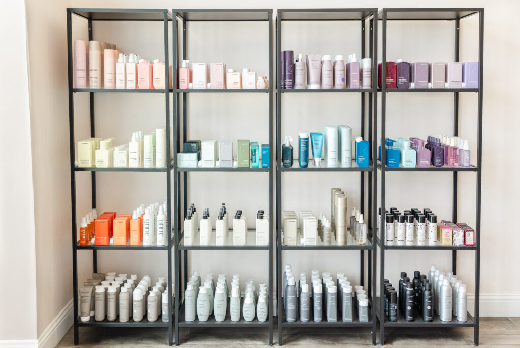 Salon retail shelves stocked with professional hair care products in sleek packaging, displayed at Pro Do Blow Dry Bar