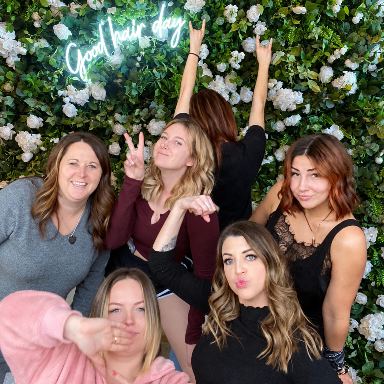 Friends taking a group photo in front of the flower wall at an Adult Glam party at The Ready Room