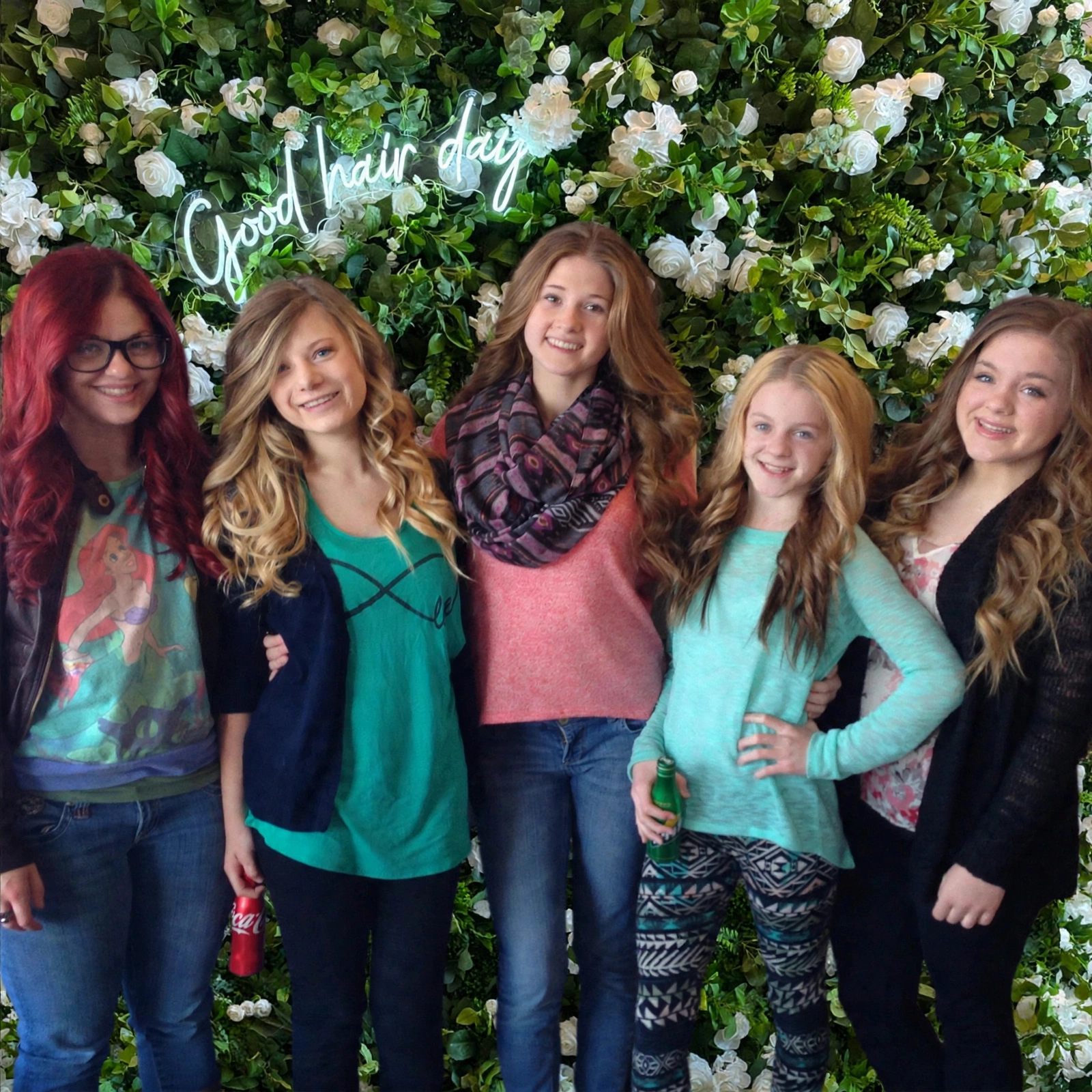 Five friends posing at the flower wall for a Pre-teen Glam birthday party